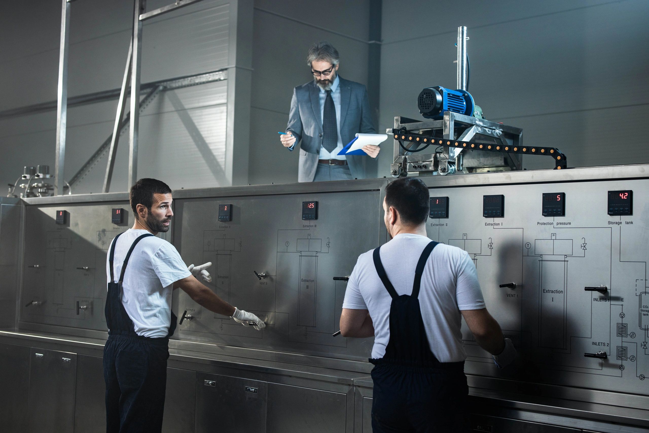 Black-and-white photo of elevator technicians working on equipment