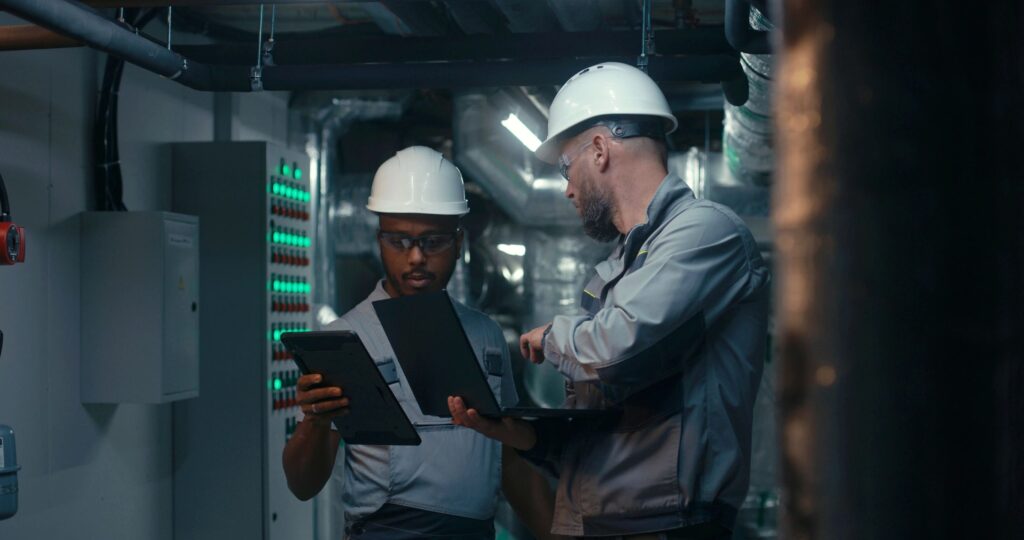 Young diverse team of factory specialists work on laptop and tablet